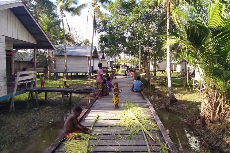 Orang dewasa dan anak-anak di Kampung Erosaman, Distrik Derkoumur, Asmat, Papua bergotong-royong membuat hiasan dari pucuk pohon sagu pada Rabu (23/3/2022). 