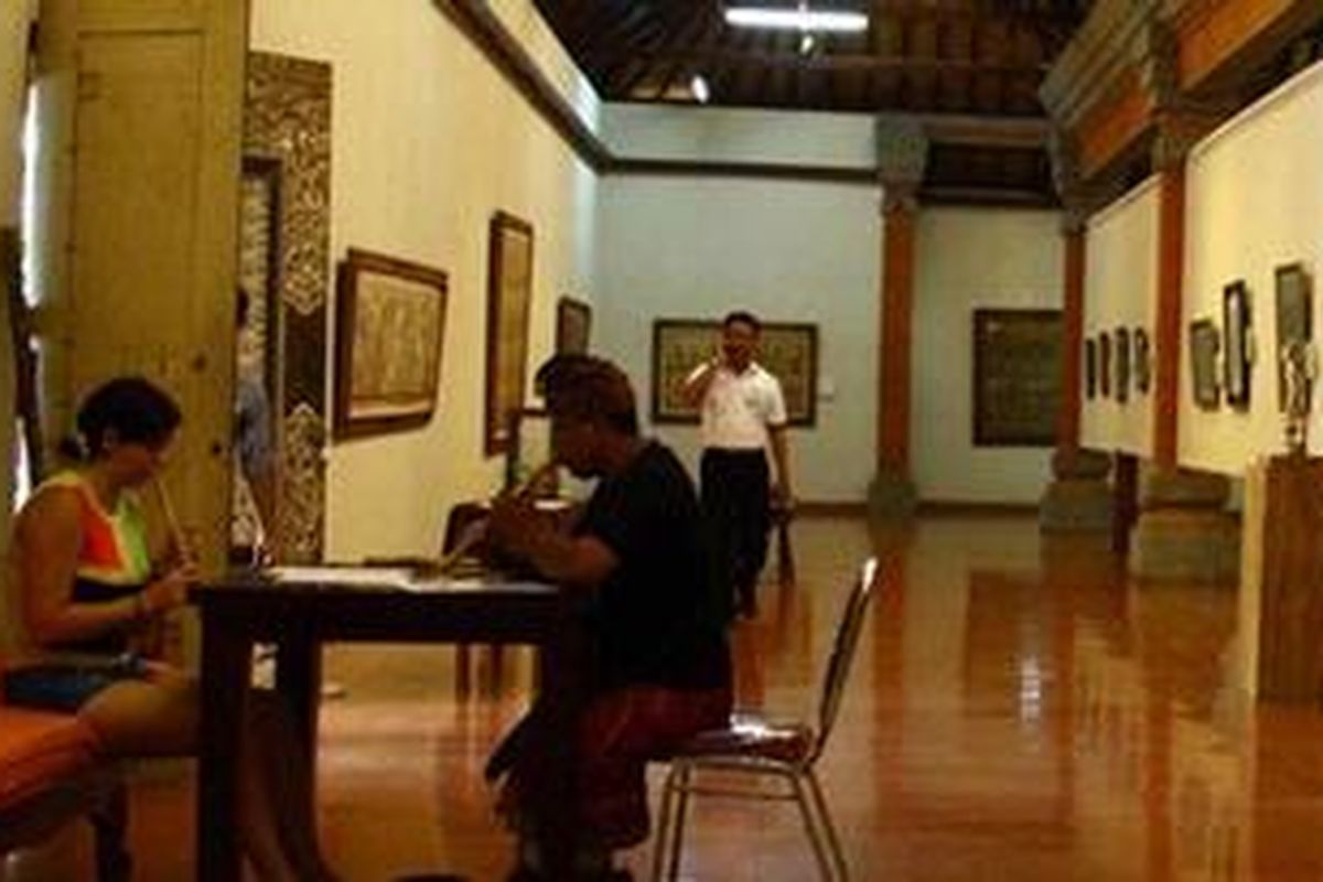 Turis belajar suling bambu di Museum Puri Lukisan di Ubud, Gianyar, Bali.