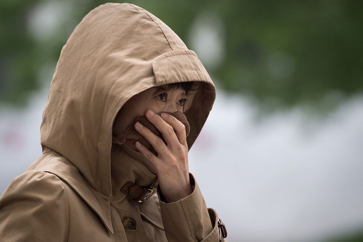 Warga menutupi hidung untuk melindungi diri dari kualitas udara yang buruk akibat badai pasir di Beijing, China, Kamis (4/5/2017). Badai pasir menerjang sebagian besar wilayah China Utara termasuk Beijing yang menyebabkan angin dipenuhi debu dan menghalangi daya pandang.