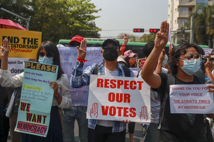 Para pengunjuk rasa memamerkan plakat dalam aksi protes di dekat Kedutaan Besar Indonesia di Yangon, Myanmar Selasa (23/2/2021). 