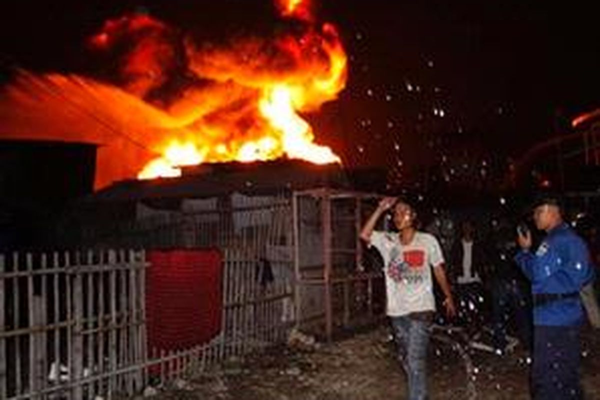 Warga bersiaga di permukiman mereka yang berada tidak jauh dari lokasi kebakaran Depo Pertamina Plumpang, Jakarta Utara, Minggu (18/1) malam.