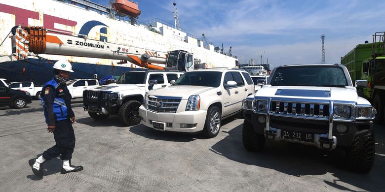 Petugas keamanan berjalan di dekat mobil mewah milik tersangka Bupati Hulu Sungai Tengah (nonaktif) Abdul Latif di Pelabuhan Tanjung Priok, Jakarta Utara, Senin (19/3). Sebanyak 16 kendaraan mewah (delapan mobil dan delapan motor) sitaan KPK dari Kalimantan Selatan yang diduga hasil gratifikasi serta pencucian uang tersangka tersebut telah tiba di Jakarta dan akan dititipkan ke Rumah Penyimpanan Benda Sitaan Negara Jakarta Barat. ANTARA FOTO/Sigid Kurniawan/aww/18.