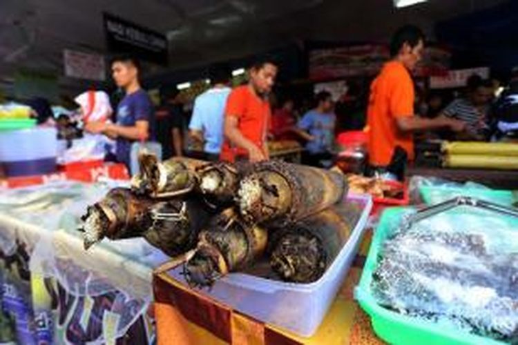 Pedagang melayani konsumen yang membeli makanan untuk berbuka puasa di pasar takjil Bendungan Hilir, Jakarta Pusat, Minggu (14/7/2013). Pasar Takjil Benhil yang beroperasi sejak pukul 11.00 WIB hingga usai waktu Magrib selama bulan Ramadan tersebut, menyediakan berbagai macam menu berbuka puasa (takjil) bagi warga Jakarta dan sekitarnya.  