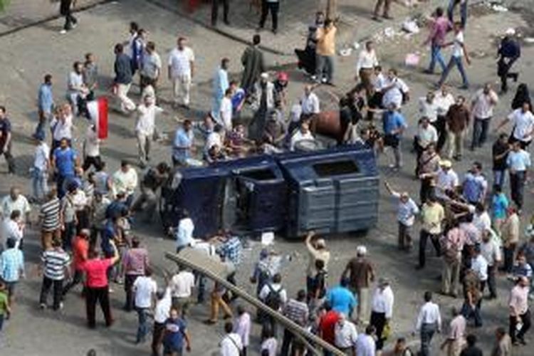 Para pendukung Muhammad Mursi dan Ikhwanul Muslimin menggulingkan sebuah mobil milik polisi di lapangan Mustafa Mahmud setelah operasi pembubaran pengunjuk rasa pro-Mursi. Akibat bentrokan sepanjang Rabu (14/8/2013), sedikitnya 343 orang tewas.