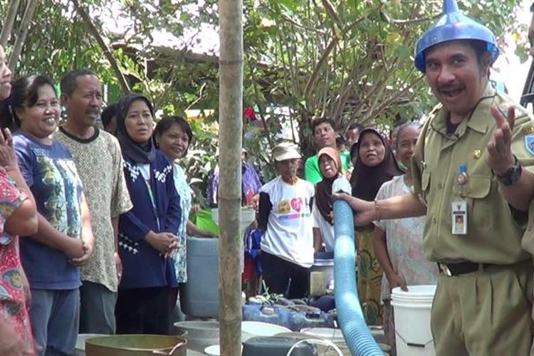 Bupati Tegal Enthus Susmono memakai corong diatas kepalanya sebelum menuangkan air bersih ke jerigen, Selasa (7/10/2014).