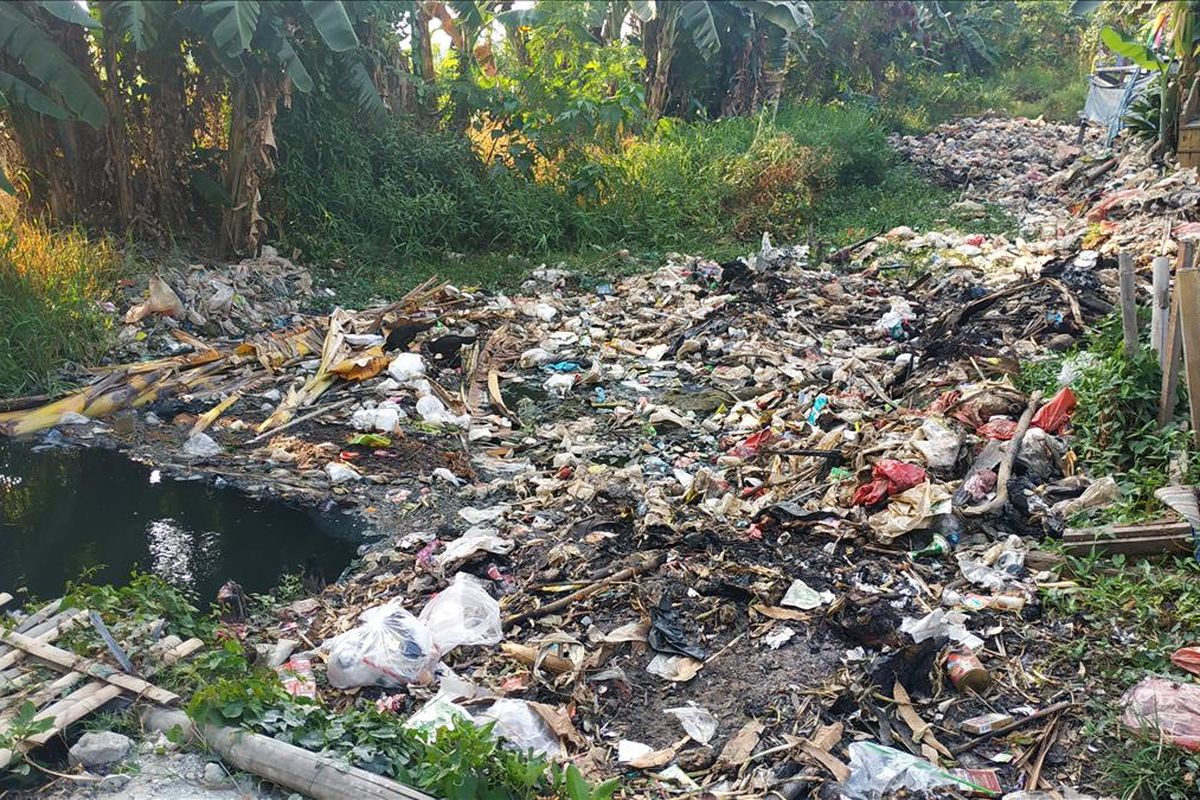 Tutupan sampah memenuhi aliran Kali Busa atau Kali Bahagia, Kecamatan Babelan, Kabupaten Bekasi.