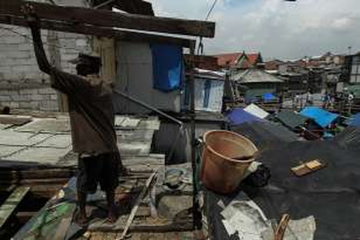 Warga memindahkan barang saat membongkar rumah mereka di Kampung Pasar Ikan, Penjaringan, Jakarta Utara, Jumat (8/4/2016). Setelah Surat Peringatan 2 diberikan Pemprov DKI, hari ini, warga Pasar Ikan mulai membongkar rumah dan lapak dagangannya.