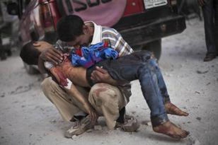FILE - Pria Suriah menangis sambil memegang jenazah anaknya di dekat RS Dar El Shifa di Aleppo, Suriah, 3 Oktober 2012. Anak itu dibunuh oleh tentara Suriah. Foto ini salah satu dari 20 foto karya fotografer AP yang memenangkan Pulitzer Prize 2013 kategori foto Breaking News.