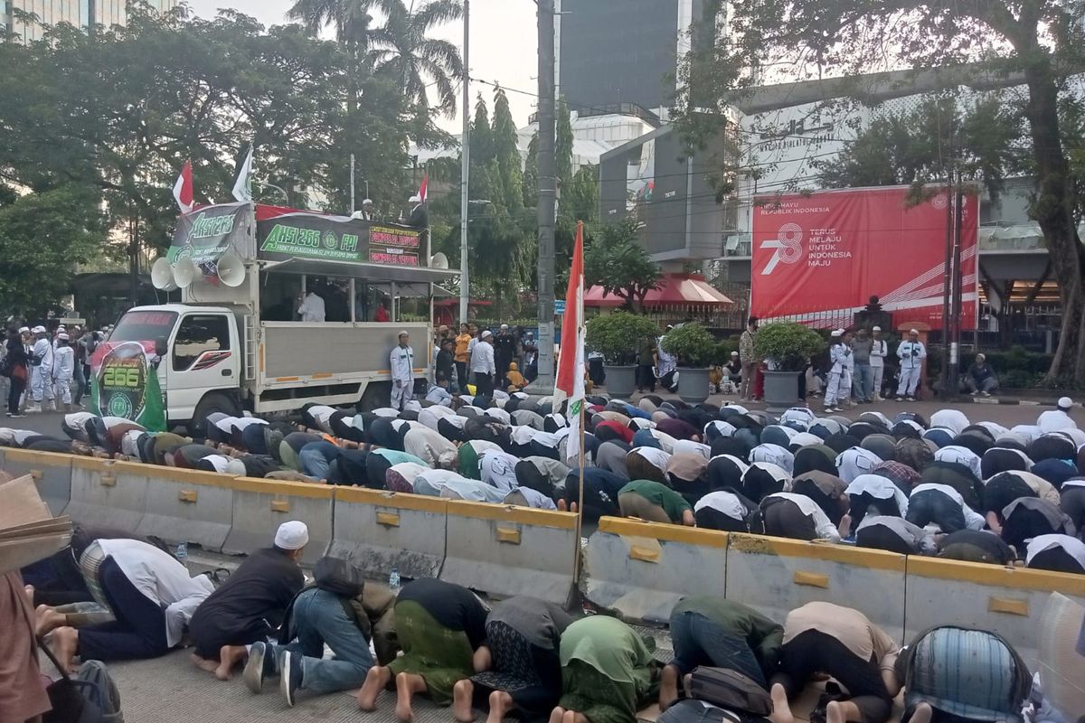 Massa demo FPI salat ashar berjamaah di sekitar Patung Kuda, Jalan Medan Merdeka Barat, Senin (26/6/2023)