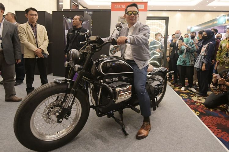 Gubernur Jawa Barat Ridwan Kamil saat berfoto di atas motor listrik RKG 5000 yang ia desain sendiri pada ajang West Java Investment Summit (WJIS) 2022 di The Trans Luxury Hotel, Kota Bandung, Jawa Barat, Rabu (5/10/2022).