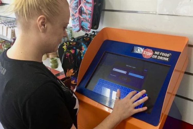 Seorang warga terlihat sedang menggunakan mesin mirip ATM yang dapat digunakan untuk meminjam uang tunai di New South Wales, Australia. (ABC News/Gavin Coote)