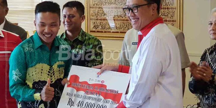 Menteri Pemuda dan Olahraga, Imam Nahrawi (kanan), memberikan penghargaan kepada karateka Indonesia, Fauzan, di Kantor Kemenpora, Jakarta Pusat, Senin (23/7/2018).
