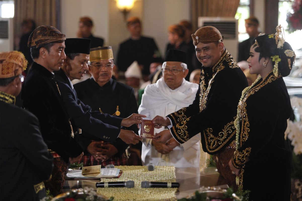 Menantu Presiden Joko Widodo, Bobby Nasution (kedua kanan) bersama istrinya, Kahiyang Ayu (kanan) menerima buku nikah dengan disaksikan Presiden Joko Widodo (kedua kiri), Wakil Presiden Jusuf Kalla (ketiga kiri) dan Ketua MUI KH Maruf Amin (keempat kanan) seusai ijab kabul di Gedung Graha Saba, Sumber, Solo, Jawa Tengah, Rabu (8/11/2017).