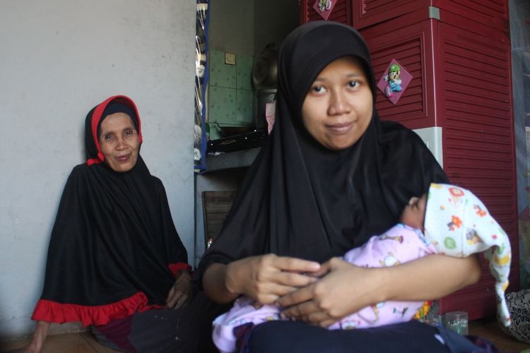 Riska (27), menggendong bayinya, yang baru berumur sepekan di rumahnya di Desa Rahong, Cianjur, Jawa Barat, Jumat (17/01/2020). Riska membayar biaya persalinan anak pertamanya itu menggunakan uang koin pecahan Rp1.000.