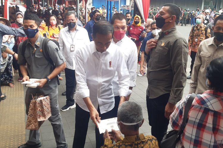 Presiden Jokowi menyerahkan Bantuan Langsung Tunai (BLT) Minyak Goreng untuk Keluarga Penerima Manfaat (KPM) Bantuan Pangan Non Tunai (BPNT) dan Program Keluarga Harapan (PKH) Tahun 2022 di Pasar Gede Solo, Jawa Tengah, Kamis (26/5/2022).