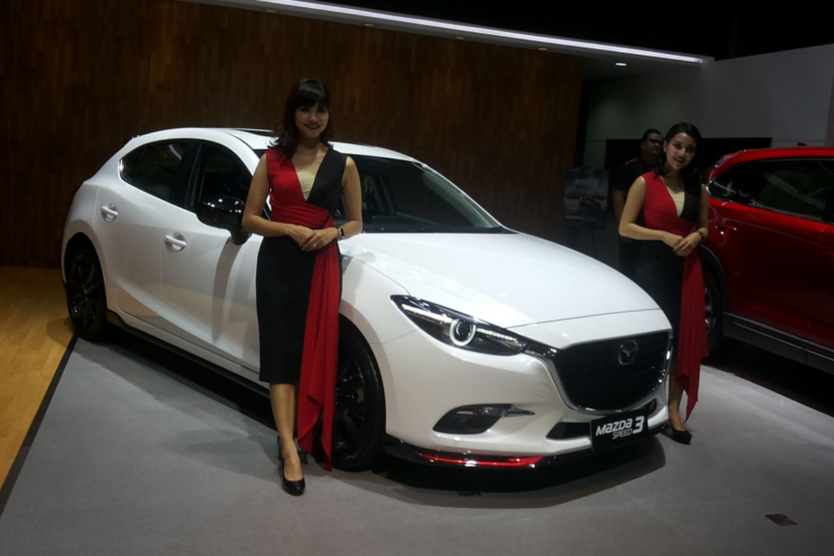 Dua orang sales promotion gilr (SPG) memperkenalkan salah satu produk andalan Mazda di stan Eurokars Motor Indonesia saat hari pertama ajang Indonesia International Motor Show (IIMS) 2018 di JIExpo Kemayoran, Jakarta, Kamis (19/4/2018).