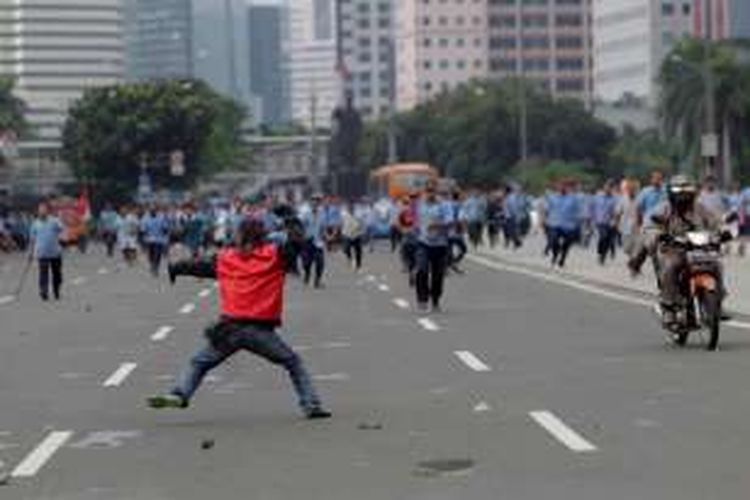 Sejumlah pengemudi ojek online terlibat aksi saling lempar batu dengan para sopir taksi yang berdemonstrasi di Jalan Sudirman, Jakarta, Selasa (22/3/2016). Aksi ini dipicu karena salah satu pengemudi ojek online disweeping oleh para demonstran.