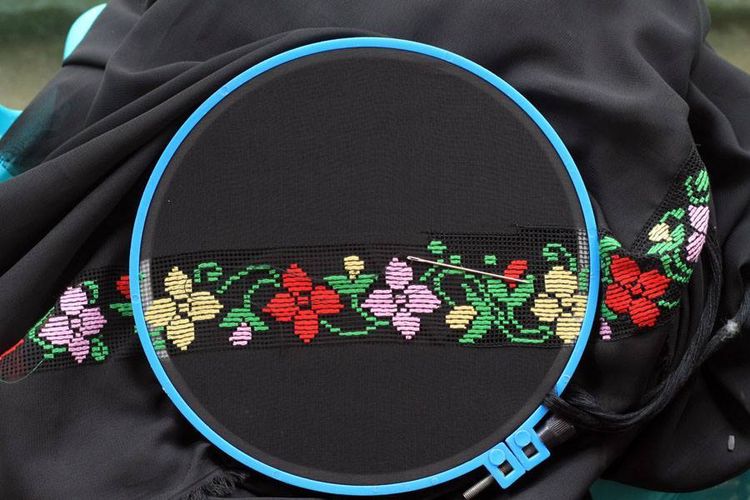 Sebuah sulaman karawo dengan pola bunga penuh warna pada selembar kain hitam. Sulaman karawo lahir dari adaptasi kerajinan kristik di tahun 1917.