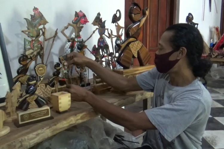 Joko Suwiono arranges his wooden wayang for customers