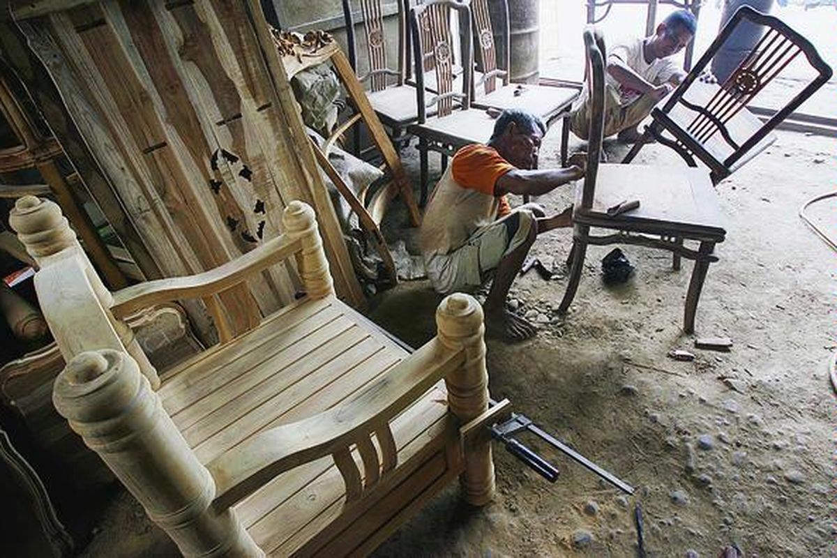 Pekerja memoles mebel dari kayu jati yang didatangkan dari Jepara di kawasan kerajinan mebel Pulo Gadung, Jakarta Utara, Kamis (8/1). Satu set meja dan kursi dijual Rp 2,5 juta-Rp 5 juta. Produsen mebel saat ini tidak hanya menghadapi melambungnya harga bahan baku kayu, tetapi juga lesunya permintaan pasar.  