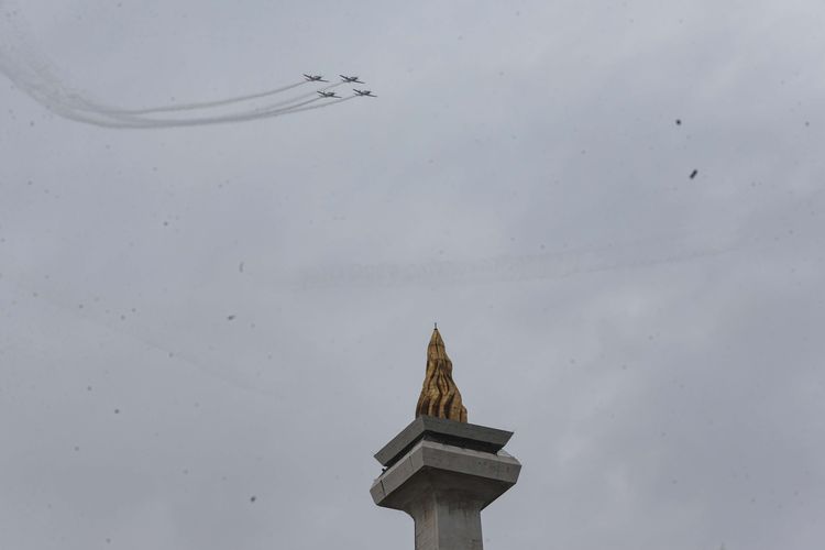 Atraksi udara  tim aerobatik Jupiter dari TNI Angkatan Udara saat perayaan HUT ke-77 TNI di atas Monumen Nasional, Jakarta, Rabu (5/10/2022).