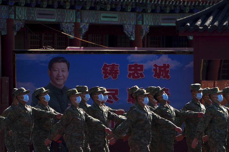 Tentara Tentara Pembebasan Rakyat (PLA) berbaris melewati poster yang menggambarkan Presiden China Xi Jinping di tempat tinggal mereka selama upacara pembukaan Kongres Nasional ke-20 Partai Komunis China yang berkuasa di Beijing, China , Minggu, 16 Oktober 2022.