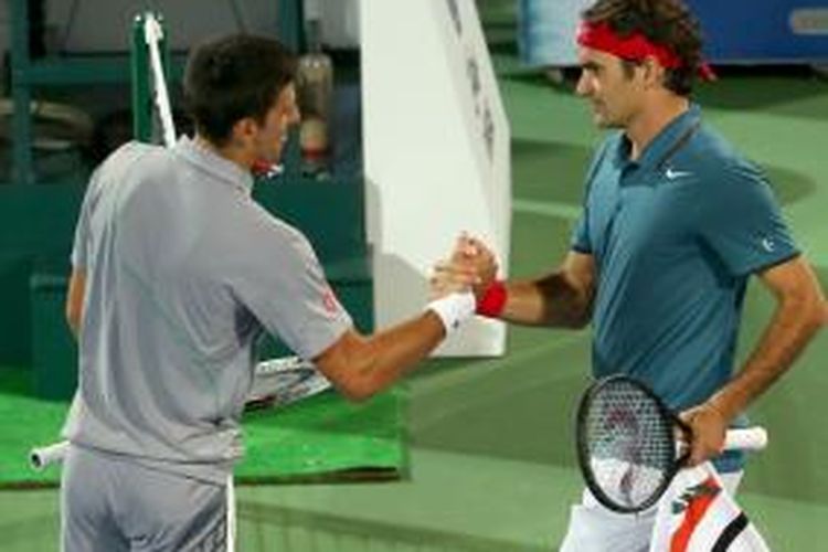 Petenis Serbia Novak Djokovic (kiri) bersalaman dengan Roger Federer dari Swiss setelah pertandingan semifinal Dubai Duty Free Tennis Championships di Dubai, Jumat (28/2/2014). Federer menang 3-6, 6-3, 6-2.