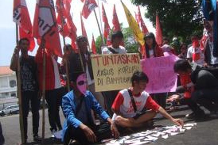 Mahasiswa PMII dan GMNI menggelar aksi teratrikal di halaman gedung DPRD Banyuwangi memperingati Hari Anti Korupsi Internasional Senin (09/11/2013)