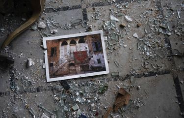 A photo rests among broken glass on the floor of the Sursock Palace, heavily damaged after the explosion in the seaport of Beirut, Lebanon, Friday, Aug. 7, 2020. The Sursock palace, built in 1860 in the heart of historical Beirut on top of a hill overlooking the now-obliterated port, is home to beautiful works of arts, Ottoman-era furniture, marble and paintings from Italy ? the result of more than three long-lasting generations of the Sursock family. (AP Photo/Felipe Dana)