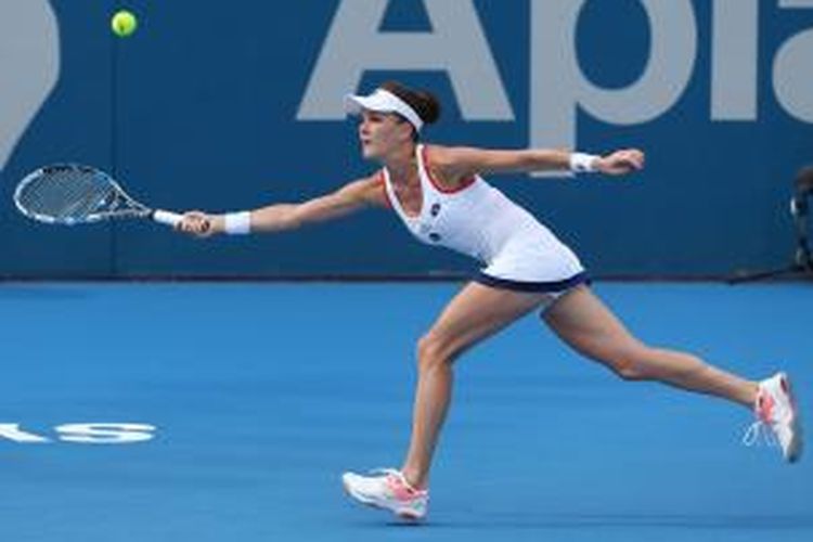 Petenis Polandia, Agnieszka Radwanska, mengembalikan bola ke arah petenis Spanyol, Garbine Muguruza, pada babak kedua Sydney International, Selasa (13/1/2015).