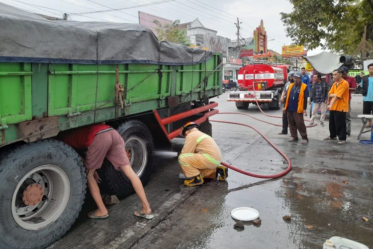 MEMADAMKAN: Petugas Damkar memadamkan kepulan asap pada roda bagian belakang truk di Jalan Ahmad Yani, Kroya, Kabupaten Cilacap, Jawa Tengah, Sabtu (25/5/2024) sore.