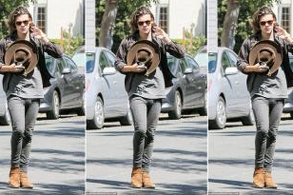 Personel boy band kenamaan One Direction, Harry Styles (20) tertangkap paparazzi menggenakan celana jeans skinny untuk perempuan