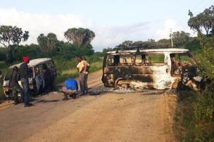 Warga kota Mpeketoni, Kenya melihat dua bangkai mobil terbakar akibat serangan kelompok Al-Shabab. Serangan yang terjadi pada Minggu (15/6/2014) itu menewaskan sedikitnya 48 orang.