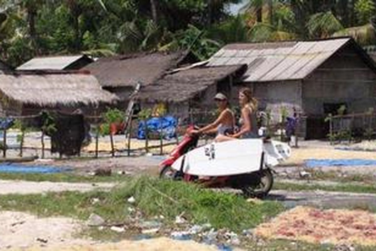 Wisman bersepeda motor di Nusa Lembongan, Bali.