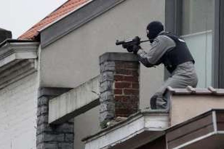 Seorang anggota pasukan khusus kepolisian Belgia dalam posisi siap tembak di sebuah atap rumah penduduk dalam sebuah penggerebekan yang berujung baku tembak di pinggiran kota Brussels, Selasa (15/3/2016).