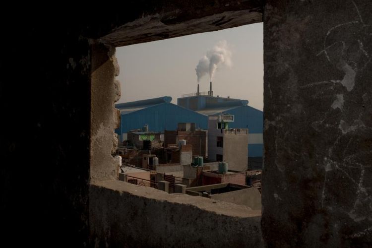 Asap membumbung tinggi dari sebuah pabrik dia area industri Sahibadab, pinggiran Delhi