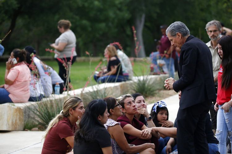 Uskup Agung San Antonio, Gustavo Garcia Seller (kanan) menghibur keluarga korban di luar Civic Center menyusul penembakan mematikan di Sekolah Dasar Robb, di Uvalde, Texas Selasa (24/5/2022)