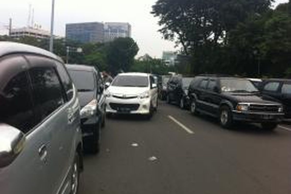 Pengunjung Monas memarkir kendaraan mereka di pinggir Jalan Medan Merdeka Selatan yang menyebabkan jalan tersebut macet, Kamis (25/12/2014).