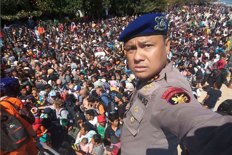 Foto handout yang diambil pada Senin, 6 Agustus 2018 menunjukkan ratusan wisatawan berkumpul di dermaga hendak meninggalkan Pulau Gili Trawangan yang terdampak gempa lombok. Kepala Pusat Data Informasi dan Humas BNPB Sutopo Purwo Nugroho lewat akun Twitternya, menyatakan ada 1.000 orang turis asing dan domestik dievakuasi dari Gili Trawangan.