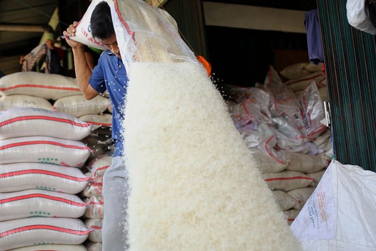 Buruh mencampur beras di Pasar Induk Beras Cipinang, Jakarta Timur, Rabu (26/7/2017). Penetapan Harga Eceran Tertinggi (HET) untuk komoditas beras memberikan pengaruh yang besar kepada para petani dan pedagang sehingga menyebabkan pasokan beras ke pasar induk anjlok.