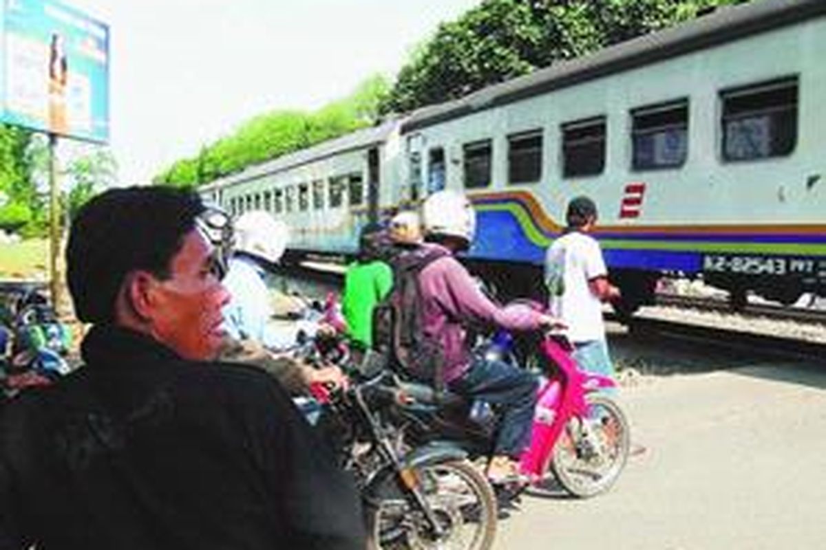 Penyeberangan di perlintasan tanpa palang di Jalan Pahlawan, Bekasi Timur, Kota Bekasi, dipandu penjaga liar, Selasa (2/9). PT Kereta Api (Persero) Daerah Operasi I Jabodetabek menandai perlintasan tak berpalang yang rawan kecelakaan. 