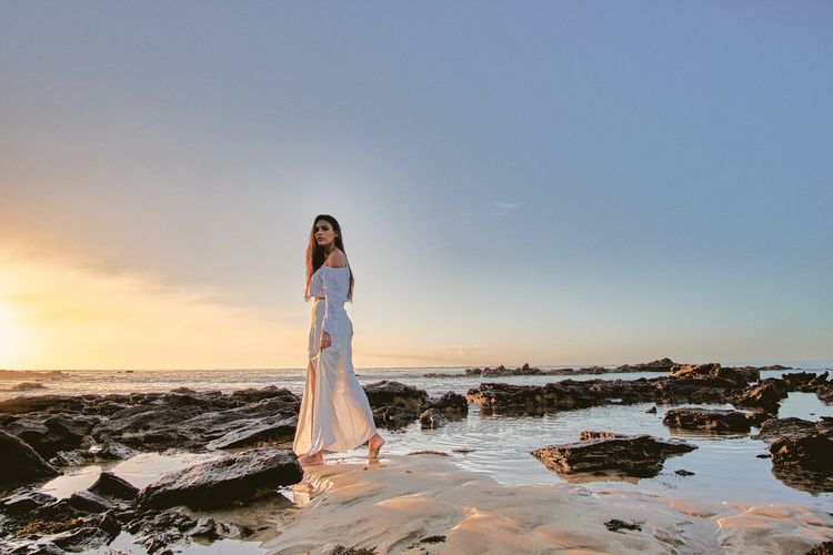 Ilustrasi gaun putih di pantai.