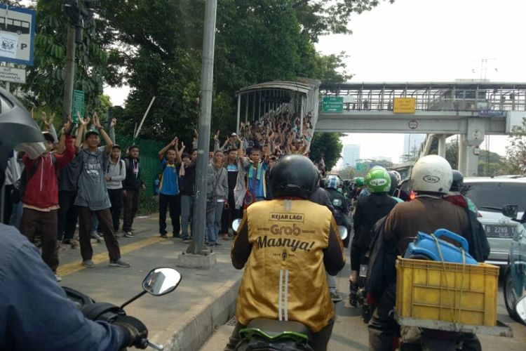 Puluhan pelajar dengan seragam lengkap berkumpul di halte depan gedung Jakarta Convention Center Jalan Gatot Subroto, Jakarta Pusat, Rabu (25/9/2019) siang. Mereka datang dengan menumpangi truk. 