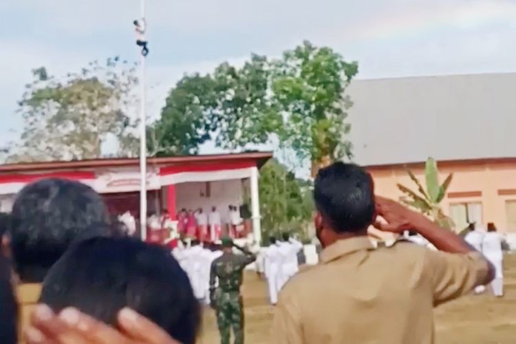 Soleman Sairo (29) sedang memanjat tiang bendera. 