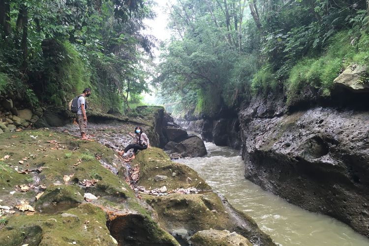 Para wisatawan sedang berjalan memasuki kawasan hutan untuk menuju ke salah satu titik Sungai Ciliwung yang memiliki pesona indah, lengkap dengan pepohona rindang, serta rerumputan dan semak belukar yang masih hijau dan asri, Kota Bogor, Senin (24/5/2021).