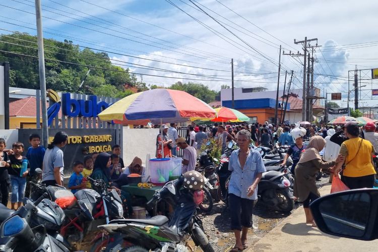 Antrean warga mengular untuk mendapatkan bantuan beras di Kantor Bulog Kota Sibolga, Kabupaten Tapanuli Tengah, Sumatera Utara pada Kamis (4/12/2025) siang.