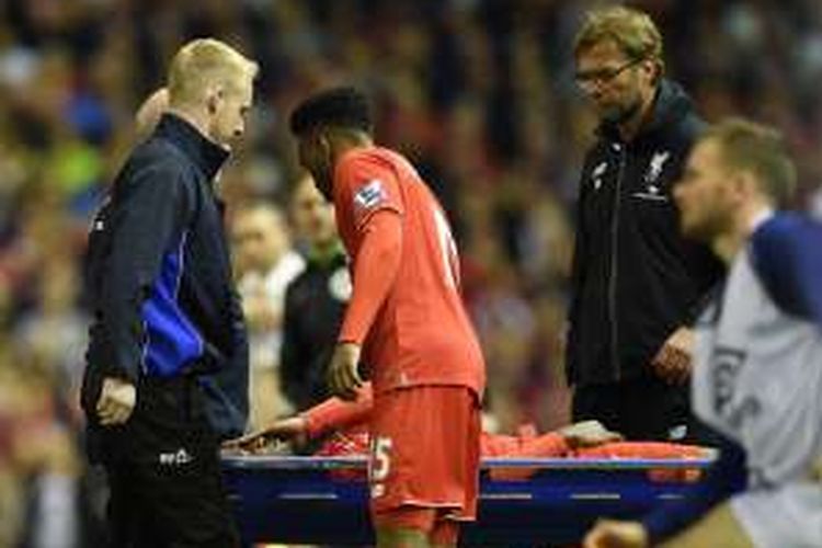 Manajer Liverpool, Juergen Klopp (kanan), menyaksikan salah satu pemainnya, Divock Origi (terbaring), ditandu ke luar lapangan akibat cedera, dalam laga Premier League di Anfield, Rabu (20/4/2016) waktu setempat.