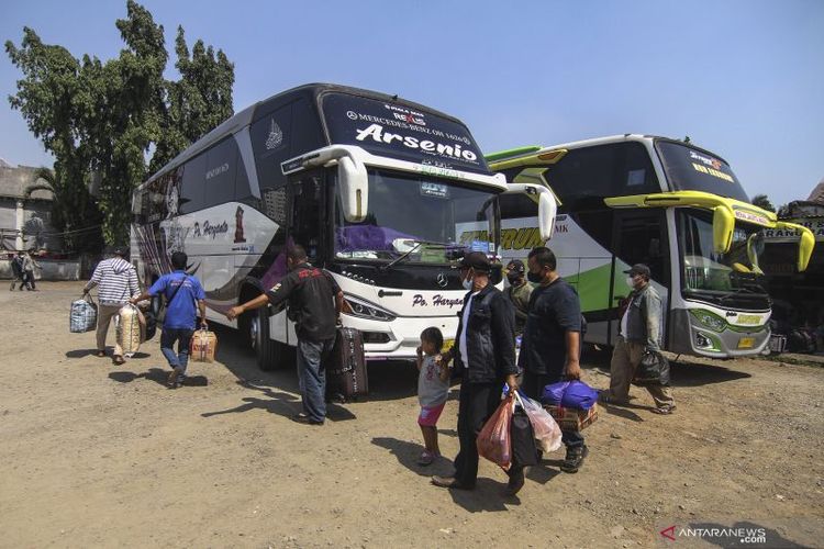 Arsip - Sejumlah calon penumpang melintas di area parkir bus AKAP di Terminal Bayangan Pondok Pinang, Jakarta, Minggu (18/7/2021).