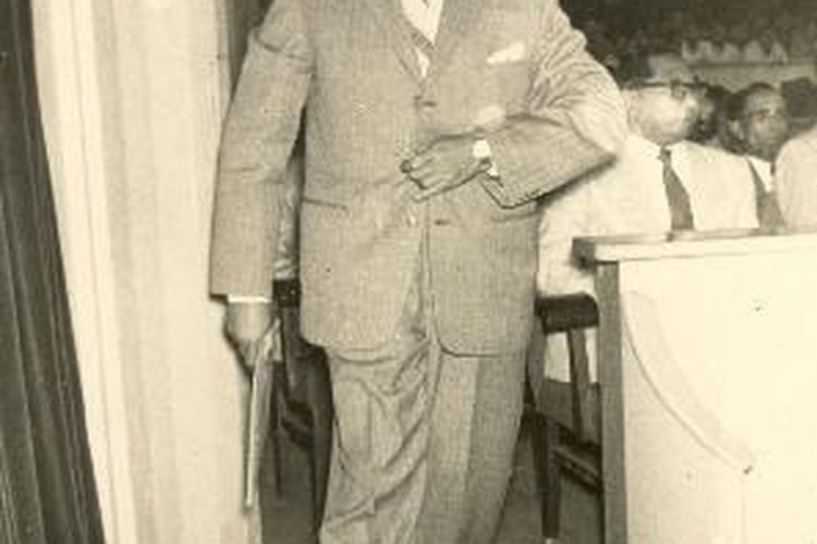 Perdana Menteri Djuanda dengan jawaban Pemerintah di tangannya waktu berjalan menuju mimbar untuk memberikan pidatonya di sidang Konstituante.