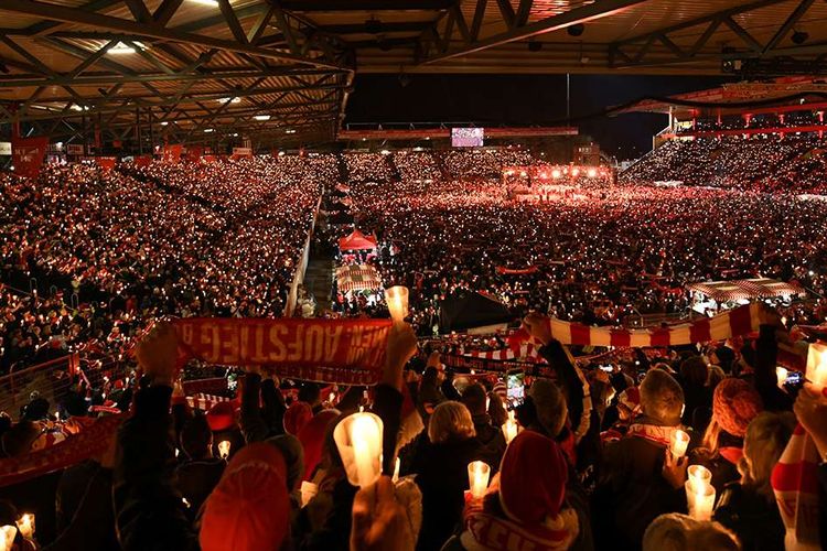 Penggemar klub sepak bola Bundesliga FC Union Berlin berkumpul di Stadion An der Alten Forsterei untuk menyanyikan lagu-lagu Natal di Berlin, Jerman, Senin (23/12/2019). Berbagai macam kegiatan penuh sukacita digelar Umat Kristiani di berbagai negara dalam menyambut perayaan Natal tahun ini.